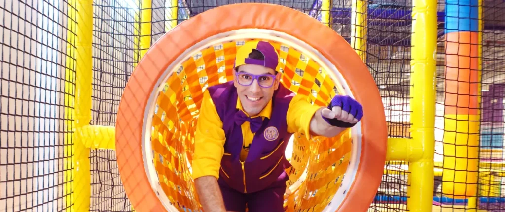 Fun Phil crawling through an orange tunnel at an indoor playground